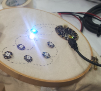 A seven-LED circuit, with power and ground lines populated throughout.  Data is populated for two LEDs, which are lit.